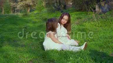 小女孩坐在草地上的公园里